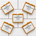 Five bars of Turmeric Butter soap from COCOLOND Soapery on a tiled surface